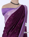 A purple silk saree with a matching purple blouse, features a deep purple body with small metallic gold motifs and a lighter lavender border.