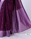 A close-up of a purple silk saree pallu with small metallic gold motifs and a matching purple border