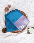 A folded blue and lavender purple silk saree with silver motifs