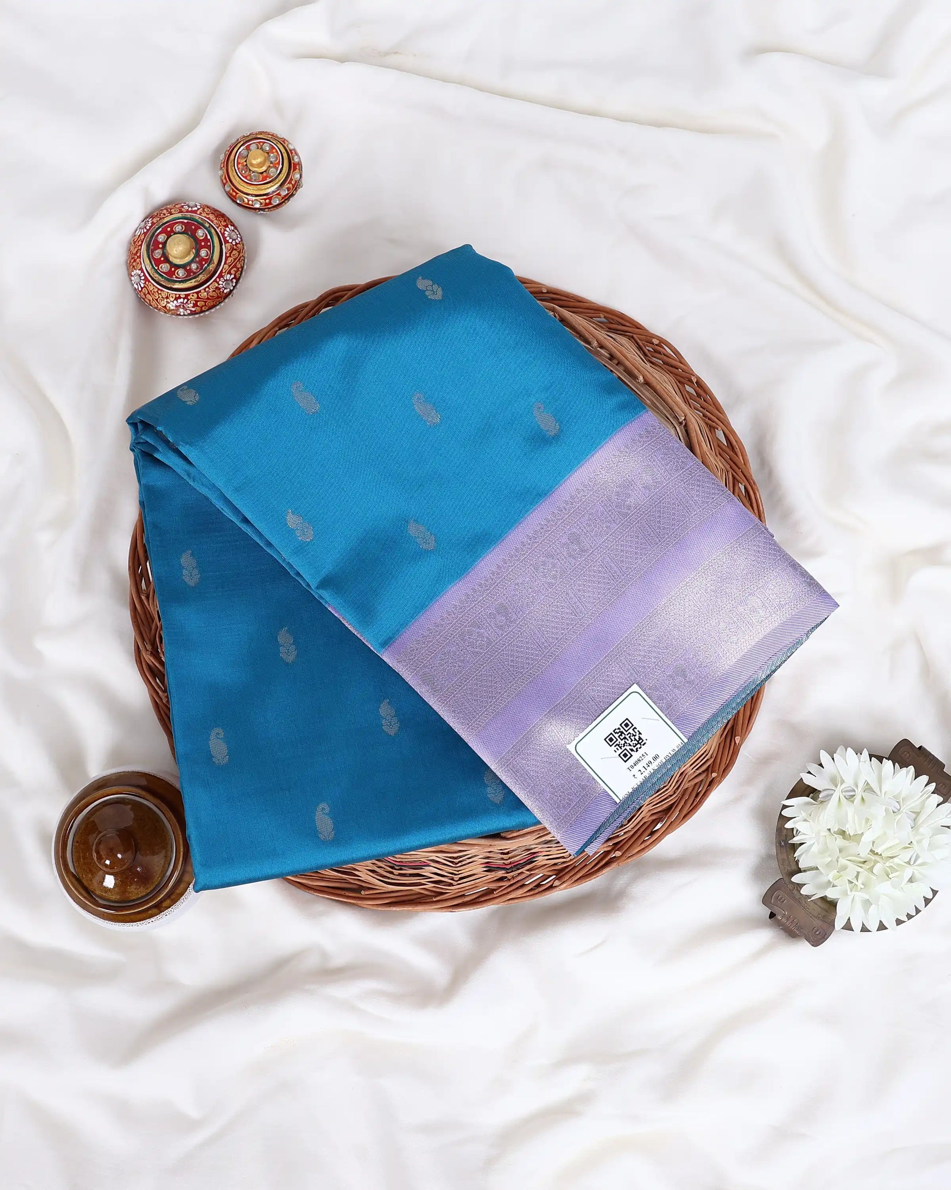 A folded blue and lavender purple silk saree with silver motifs