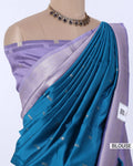 A purple and teal blue saree displayed on a mannequin torso, featuring a lavender blouse with silver zari borders