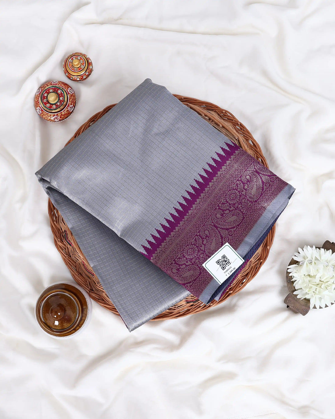 A gray silk saree with a deep purple border and a matching purple blouse 