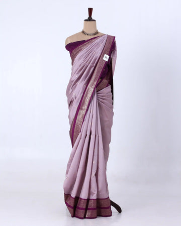 A lavender purple silk saree with a metallic gold border