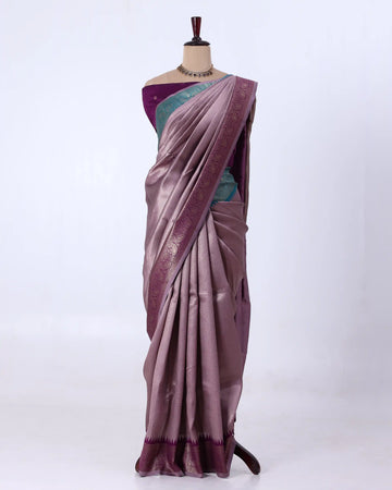 A draped purple saree with a teal-green blouse and a metallic purple border
