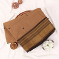 Chettinad cotton saree with zari buttas and zari border in beige and brown folded top view