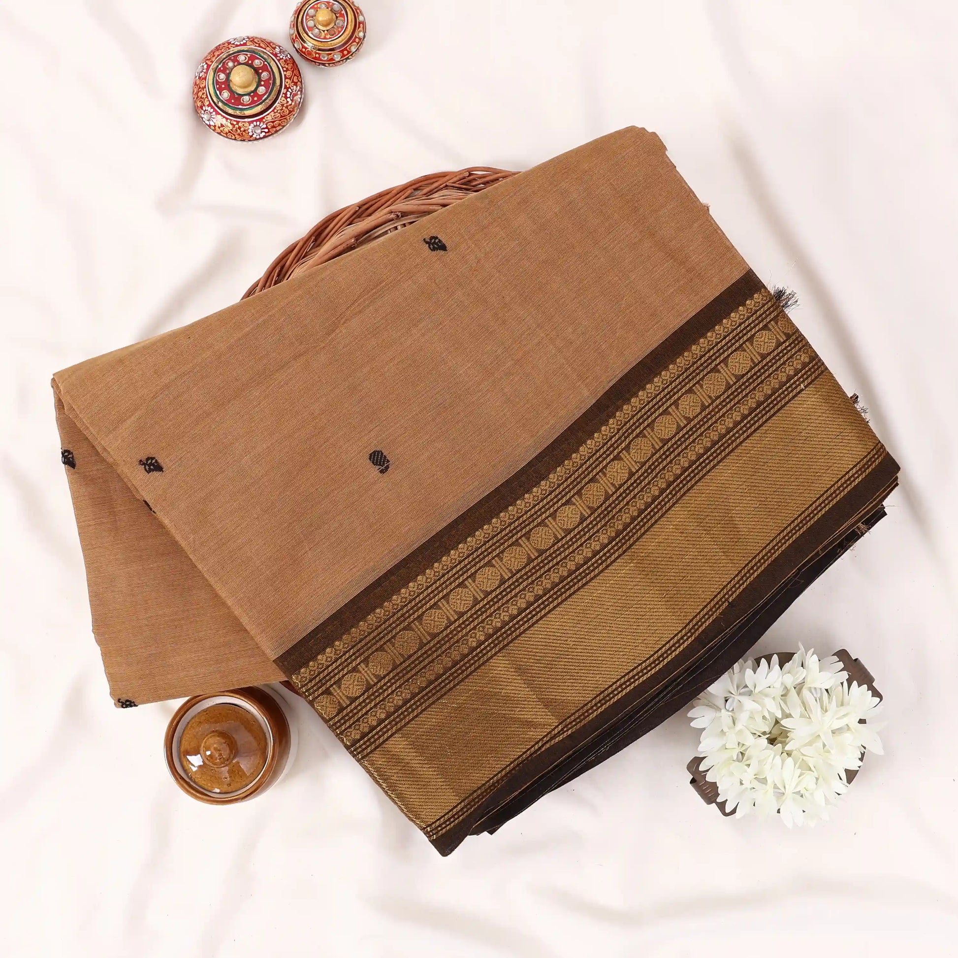 Chettinad cotton saree with zari buttas and zari border in beige and brown folded top view