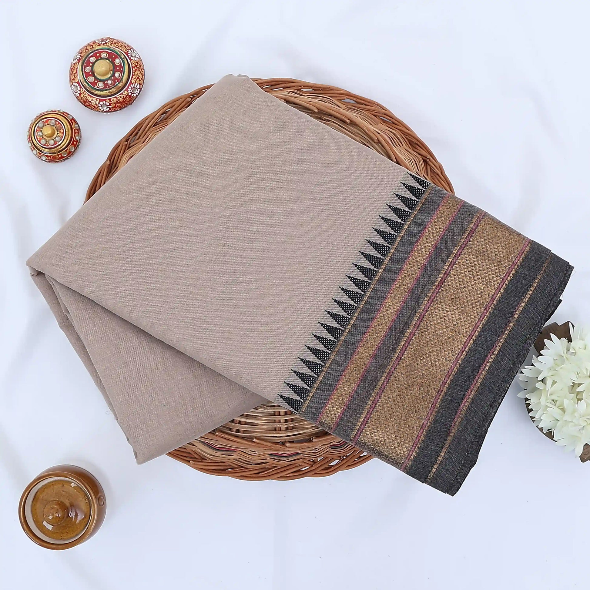 Chettinad cotton saree with plain body and temple zari woven border in beige folded top view
