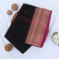 Chettinad cotton saree with red butta motifs and pink zari woven border in black folded top view