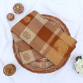 Chettinad cotton saree with beige and brown checked body paisley zari border folded flat lay view