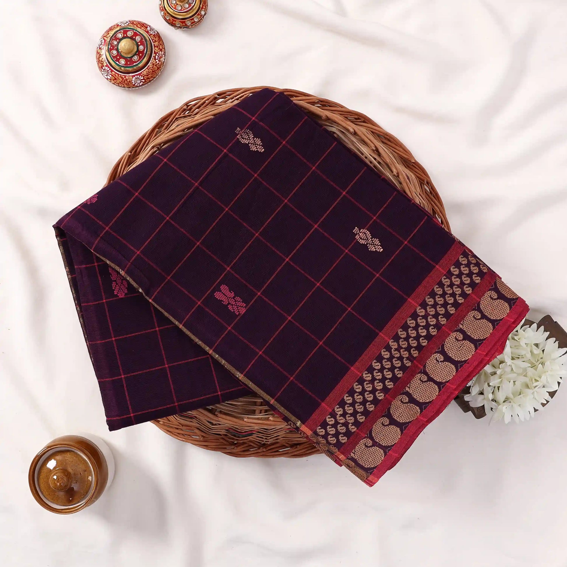 Chettinad cotton saree with checked pattern in deep purple and pink zari woven border folded flat lay front view.