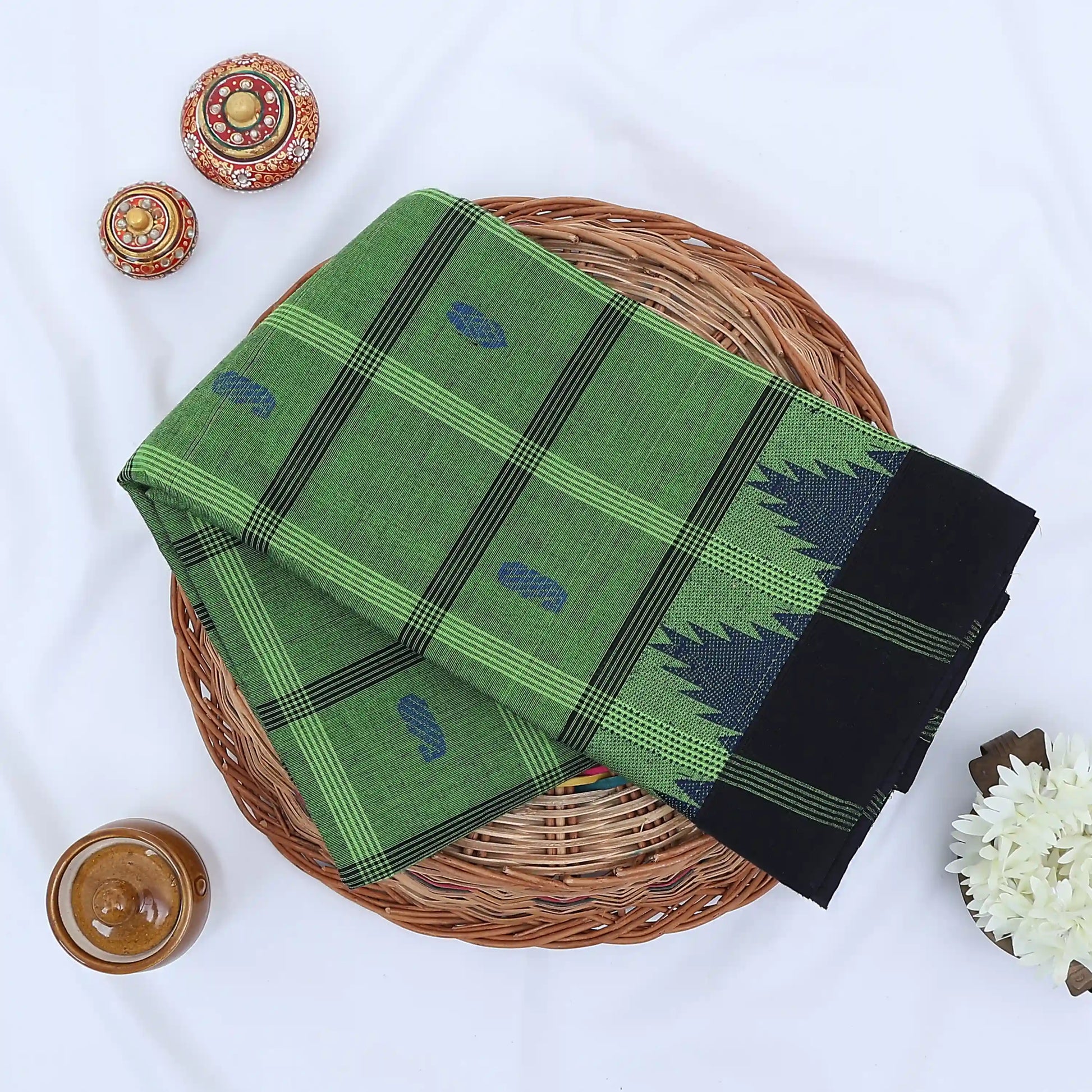 Chettinad cotton saree with green checked body blue butta motifs and temple border folded flat lay view