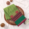 Chettinad cotton saree with striped pattern in light green contrast teal and maroon zari border folded flat lay front view.