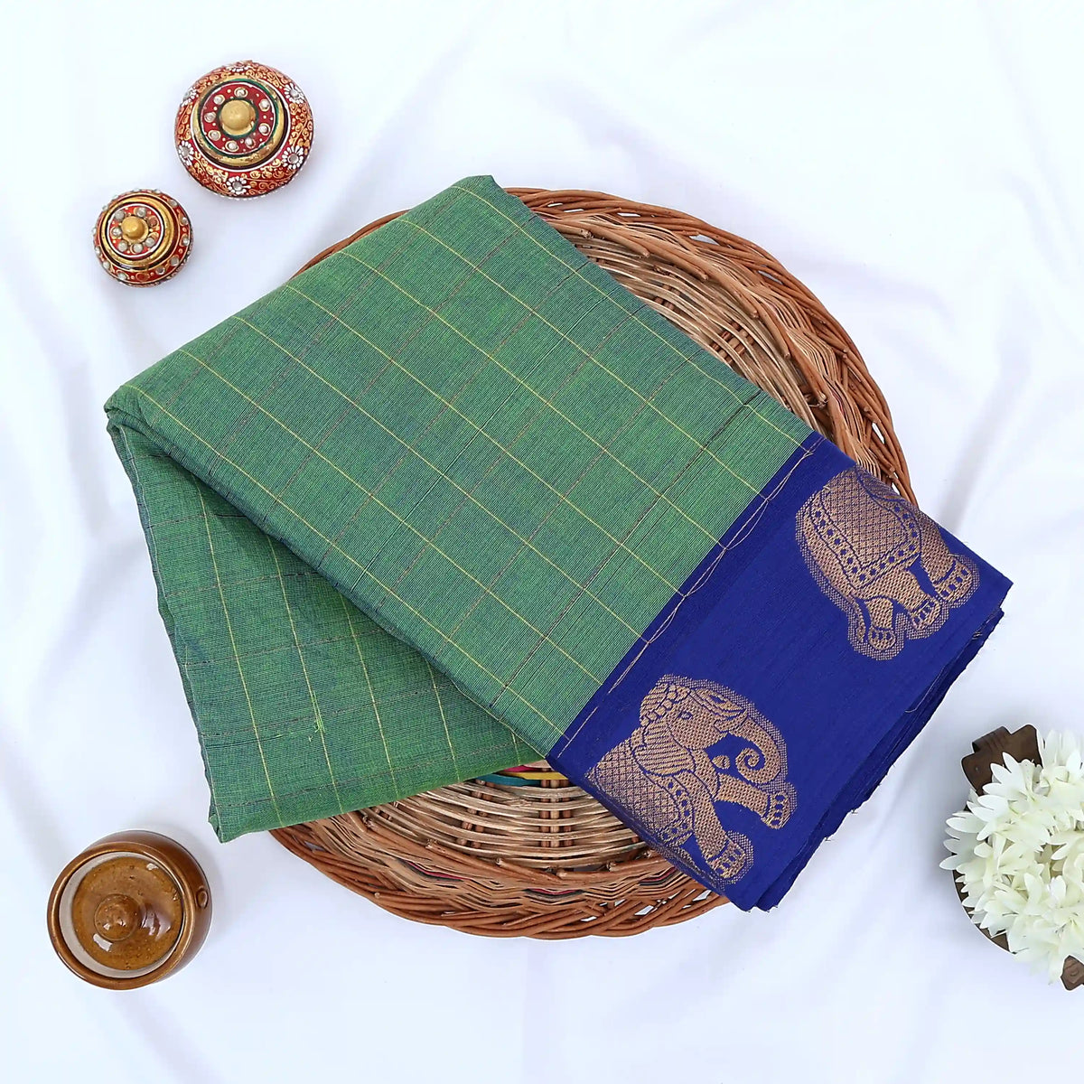 Chettinad cotton saree with elephant zari border and checked body in green and blue folded top view.