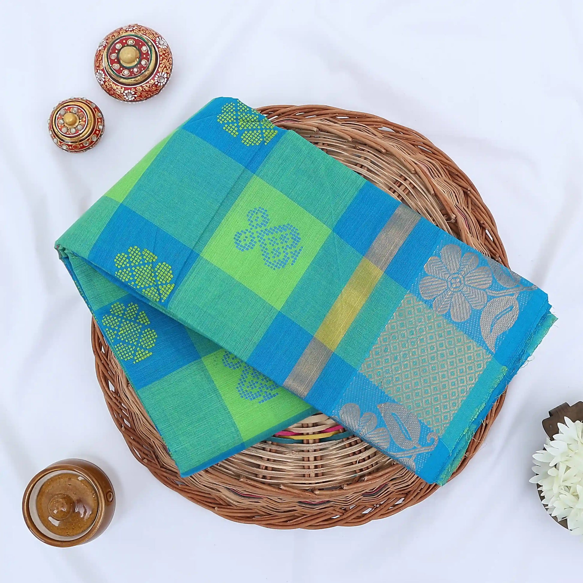 Chettinad cotton saree with green and blue checked body silver floral zari border folded flat lay view