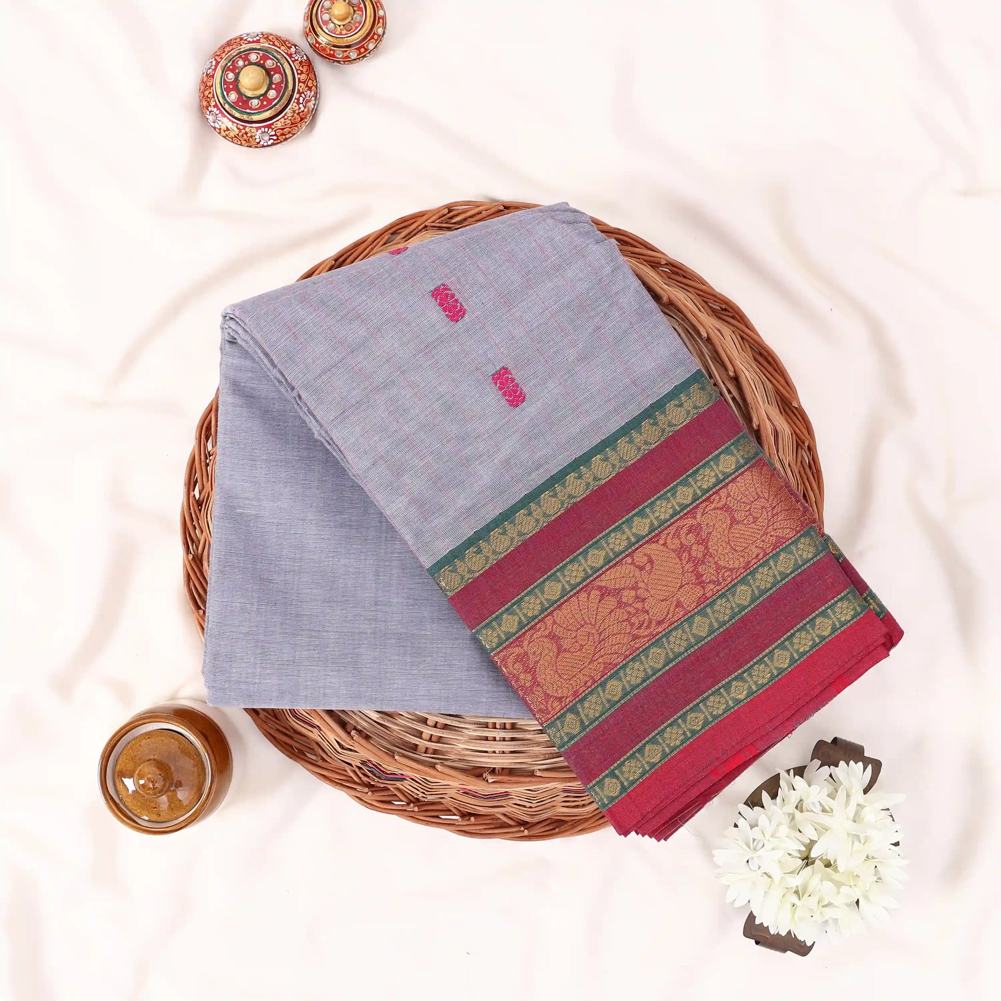 Chettinad cotton saree with zari floral butta striped body peacock border in grey folded top view
