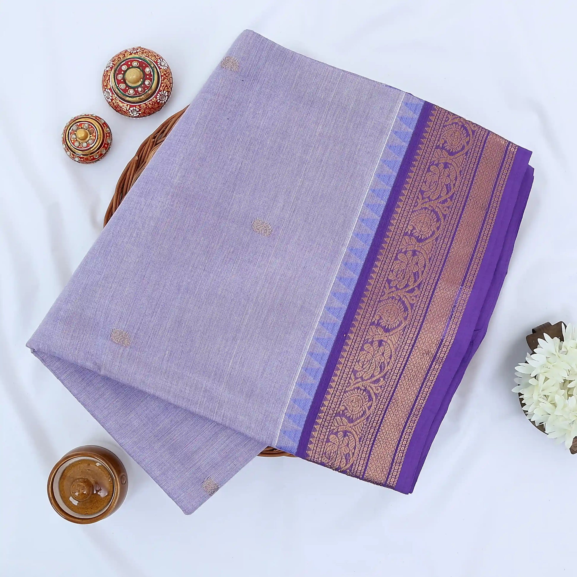 Chettinad cotton saree with lavender body gold zari buttas and purple zari woven border folded top view