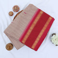 Chettinad cotton saree with plain light brown body red zari border folded top view on wicker basket