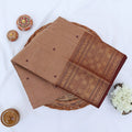 Chettinad cotton saree with plain light brown body checked zari border and woven butta motifs folded top view.