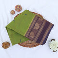 Chettinad cotton saree with peacock buttas and peacock zari woven border in light green folded top view
