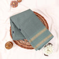 Chettinad cotton saree with checked body and zari border in light green folded top view