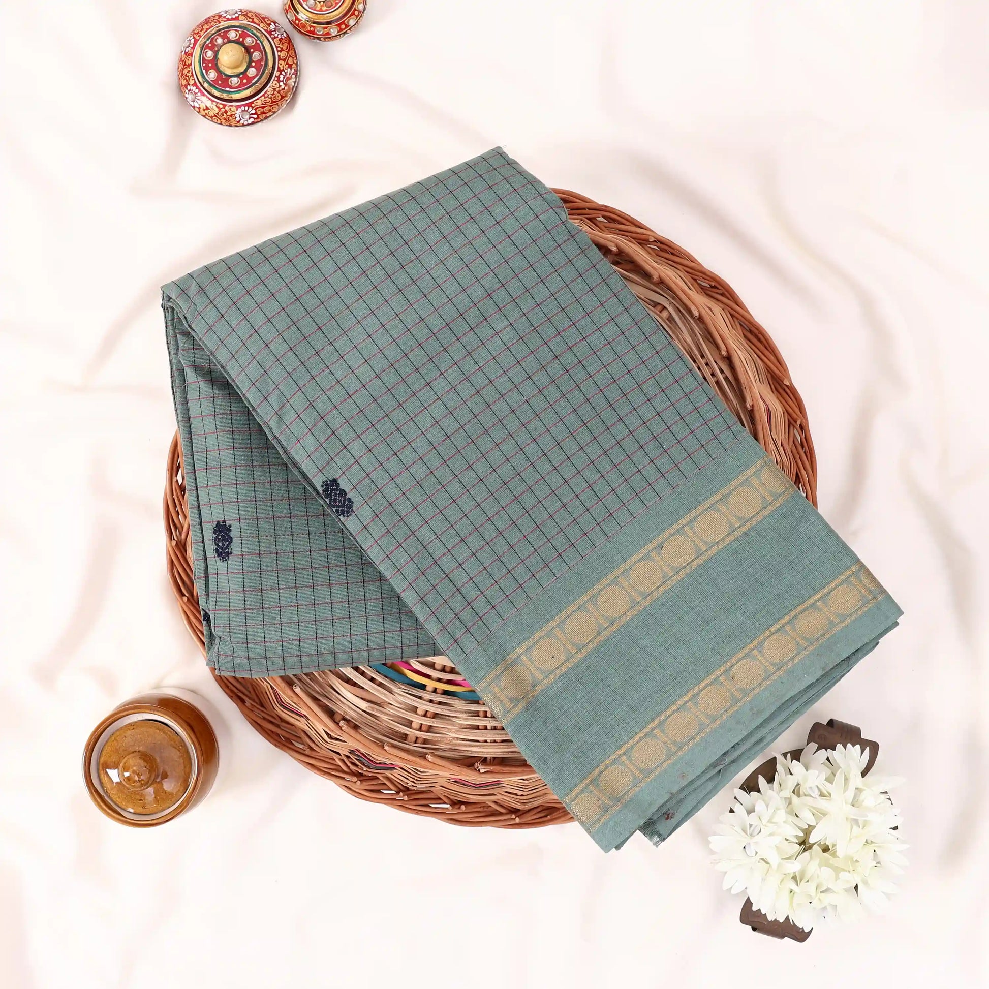 Chettinad cotton saree with checked body and zari border in light green folded top view