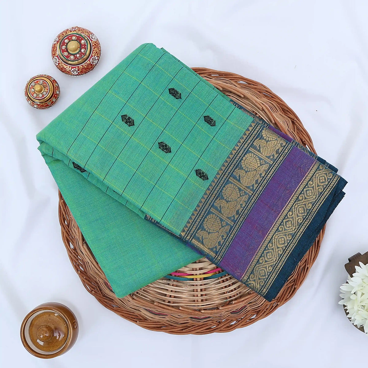 Chettinad cotton saree with zari buttas checked body peacock zari border in purple and green folded top view
