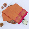 Chettinad cotton saree with orange body and pink zari border folded top view with woven motifs.