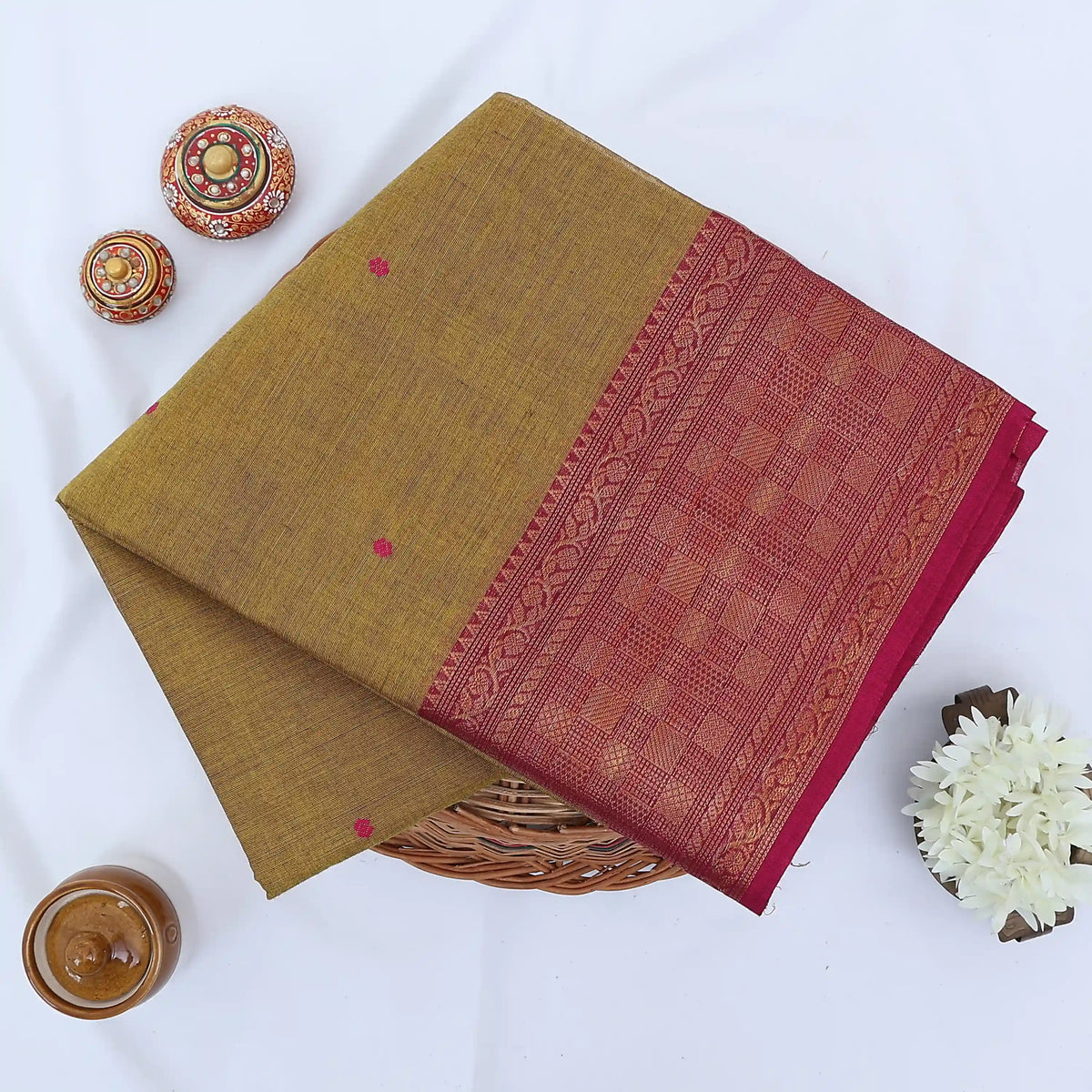 Chettinad cotton saree with plain olive green body checked zari border and woven butta motifs folded top view.