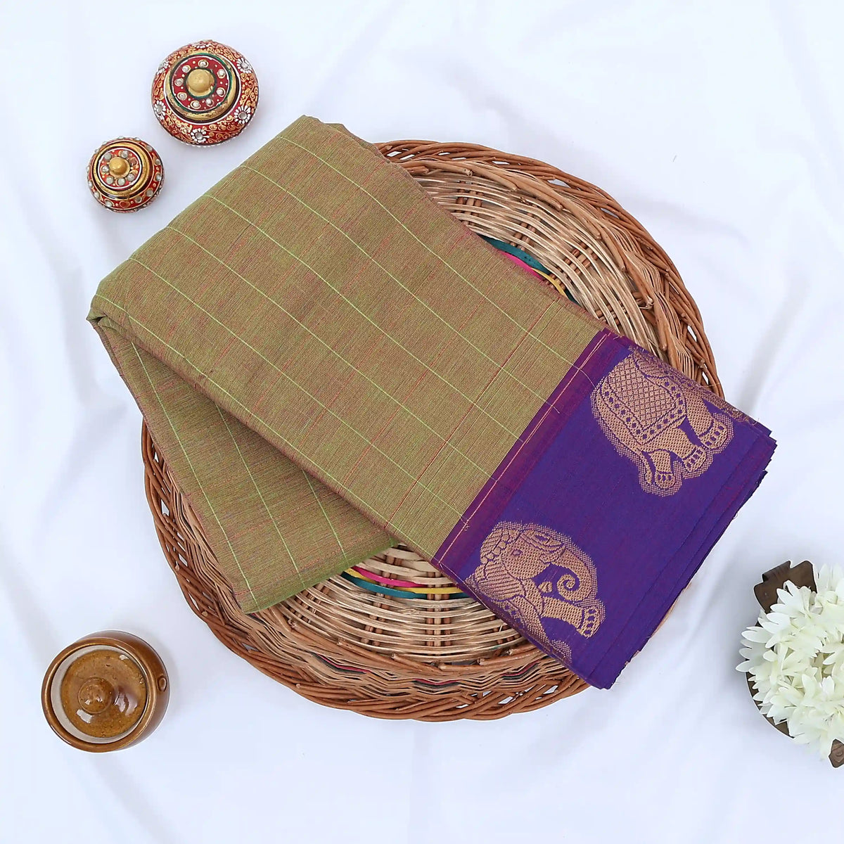 Chettinad cotton saree with elephant zari border and checked body in olive and blue folded top view.