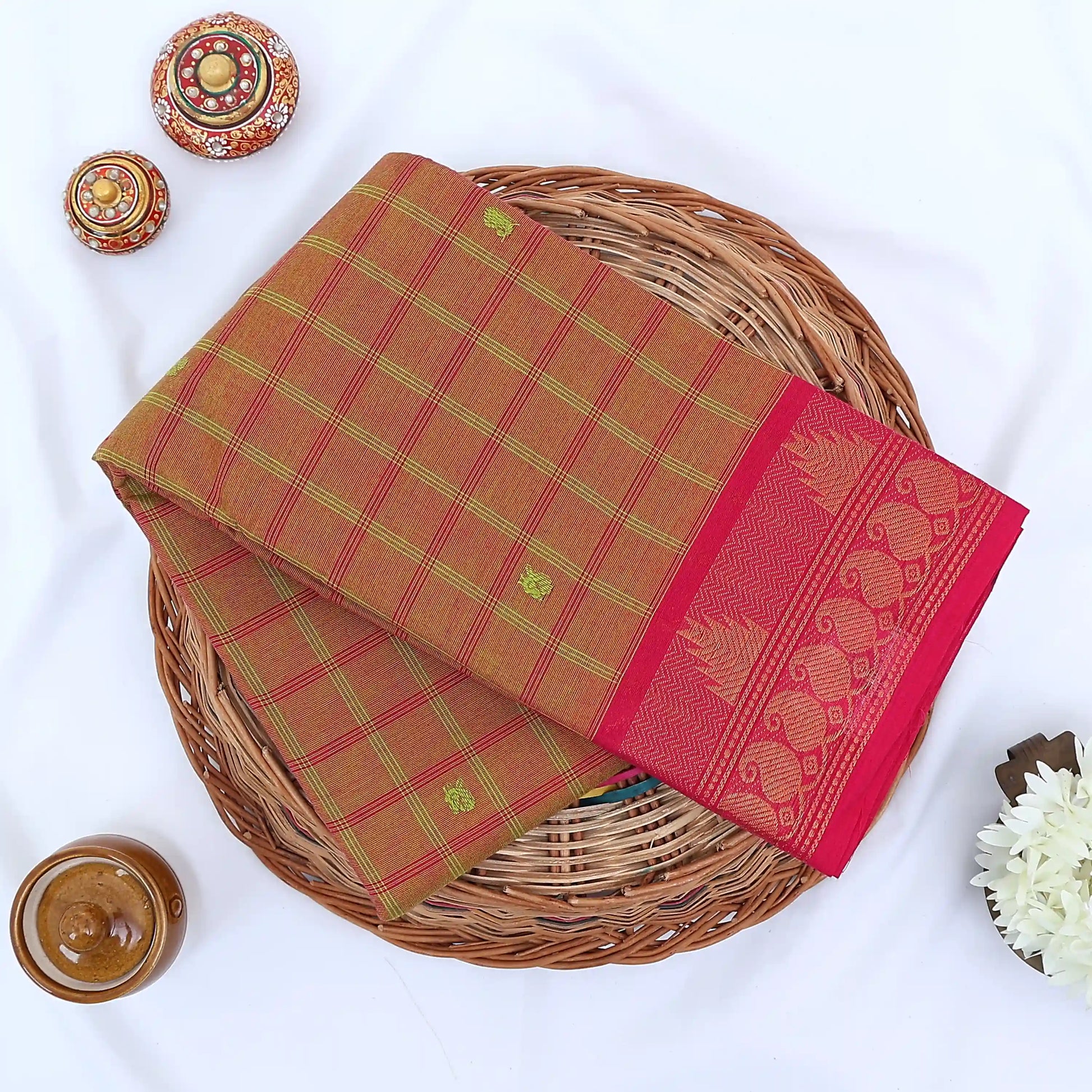 Chettinad cotton saree with olive checked body pink peacock zari border and butta motifs folded flat lay view