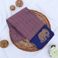 Chettinad cotton saree with elephant zari border and checked body in onion Pink and blue folded top view.