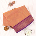 Chettinad cotton saree with zari buttas and floral zari border in orange and purple folded top view.