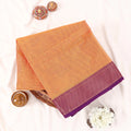 Chettinad cotton saree with plain body and contrast zari border in orange and purple folded top view.