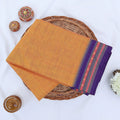 Chettinad cotton saree with plain body and temple border in orange and purple folded top view