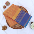 Chettinad cotton saree with orange striped body purple zari border and peacock motifs folded flat lay view