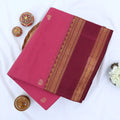 Chettinad cotton saree with zari butta motifs and maroon zari woven border in pink folded top view