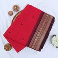 Chettinad cotton saree with plain pink body black buttas and maroon zari woven border folded top view