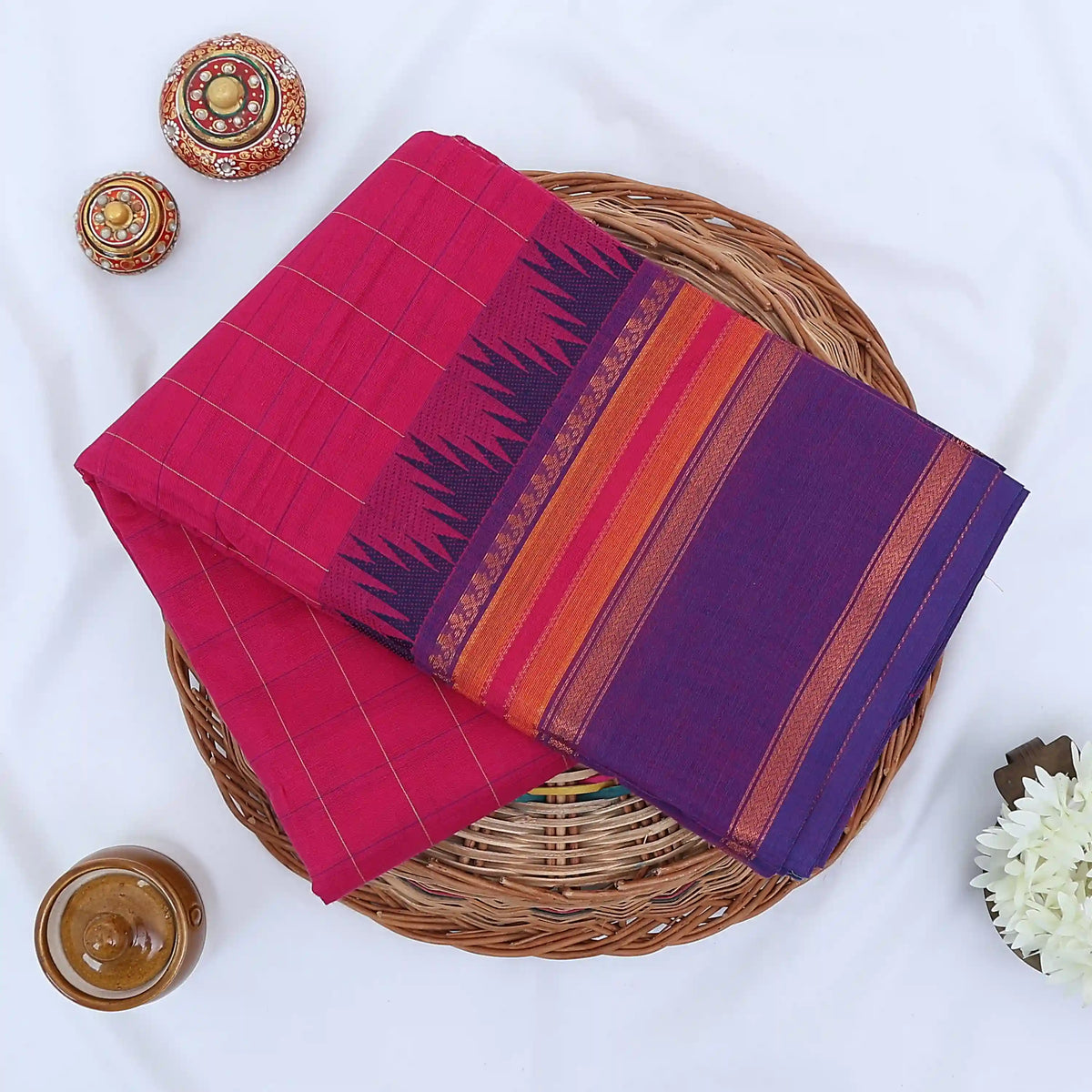 Chettinad cotton saree with striped body and temple zari border in purple and pink folded top view