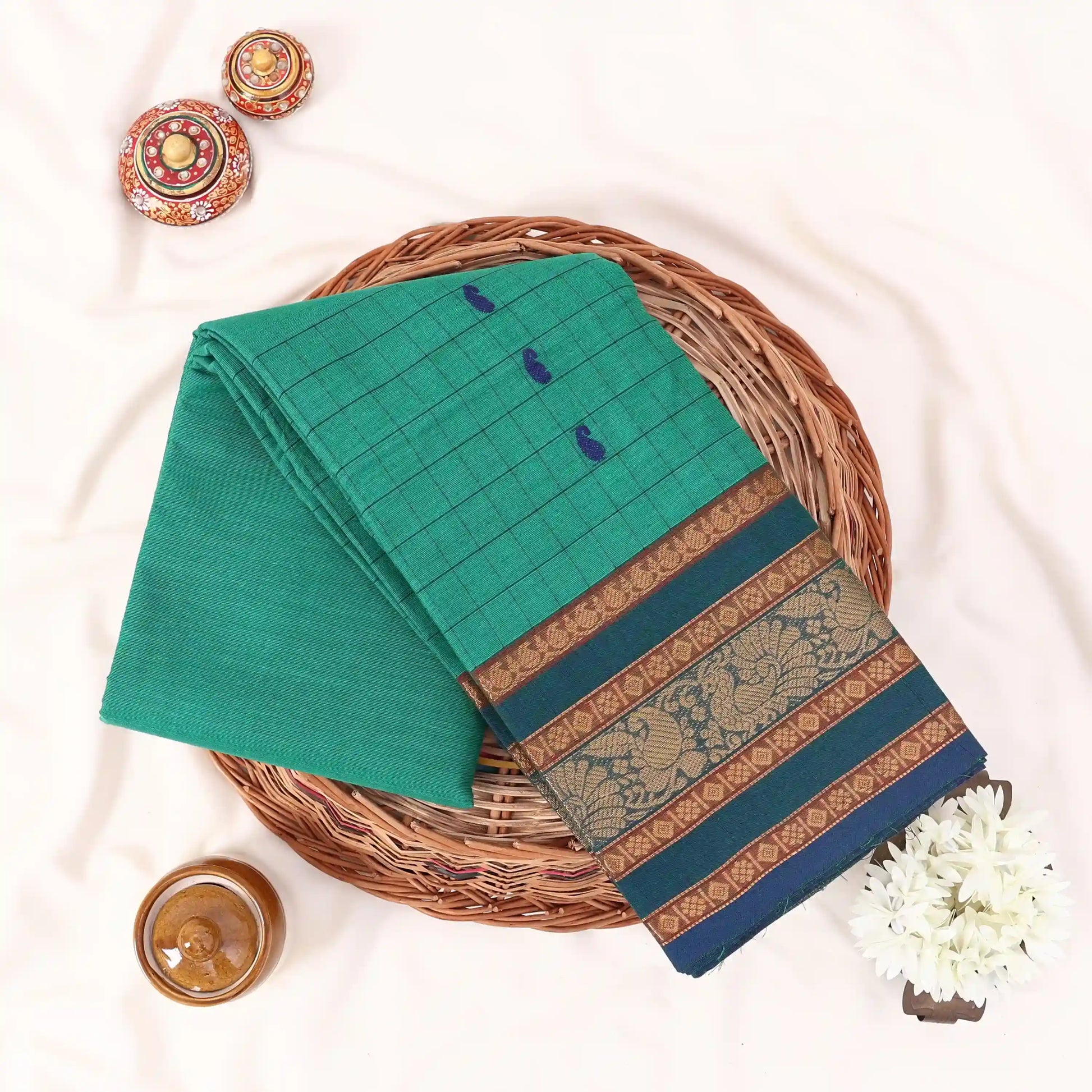 Chettinad cotton saree with zari floral butta striped body peacock border in green folded top view