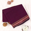 Chettinad cotton saree with contrast woven border in deep purple folded top view with border detail.