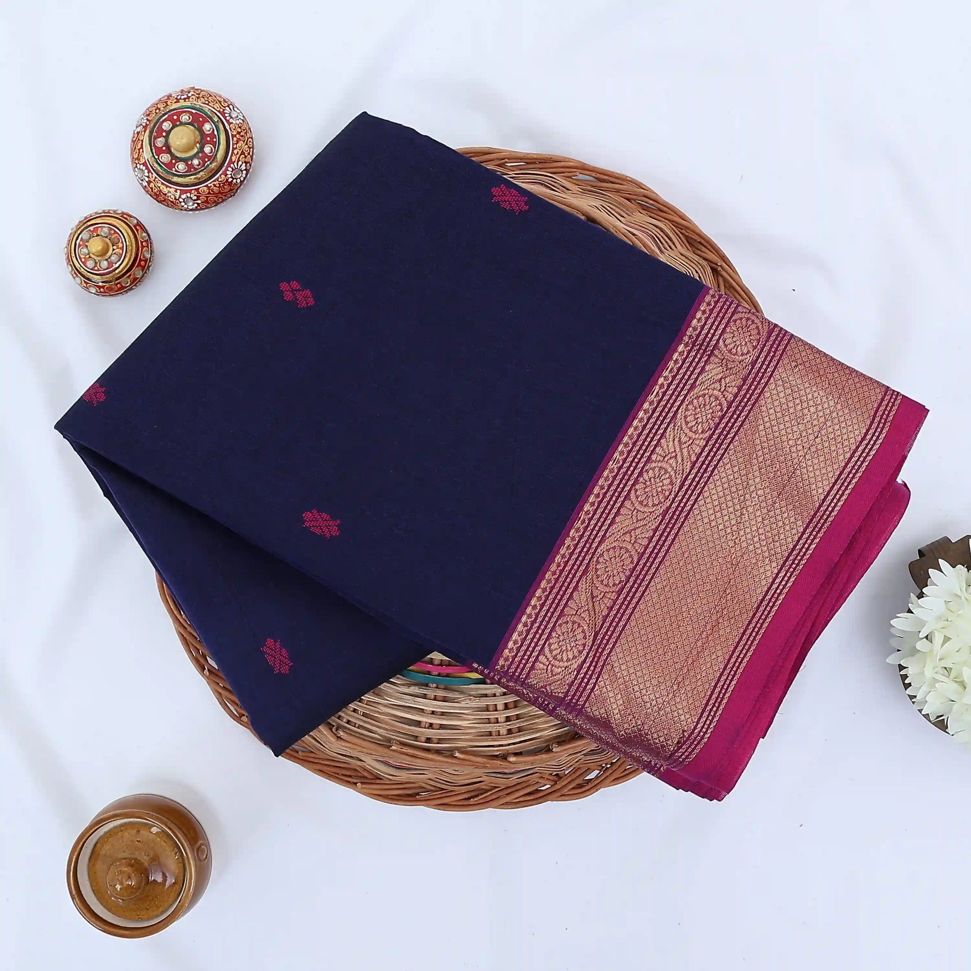 Chettinad cotton saree with zari border in navy blue and magenta folded top view with woven motifs
