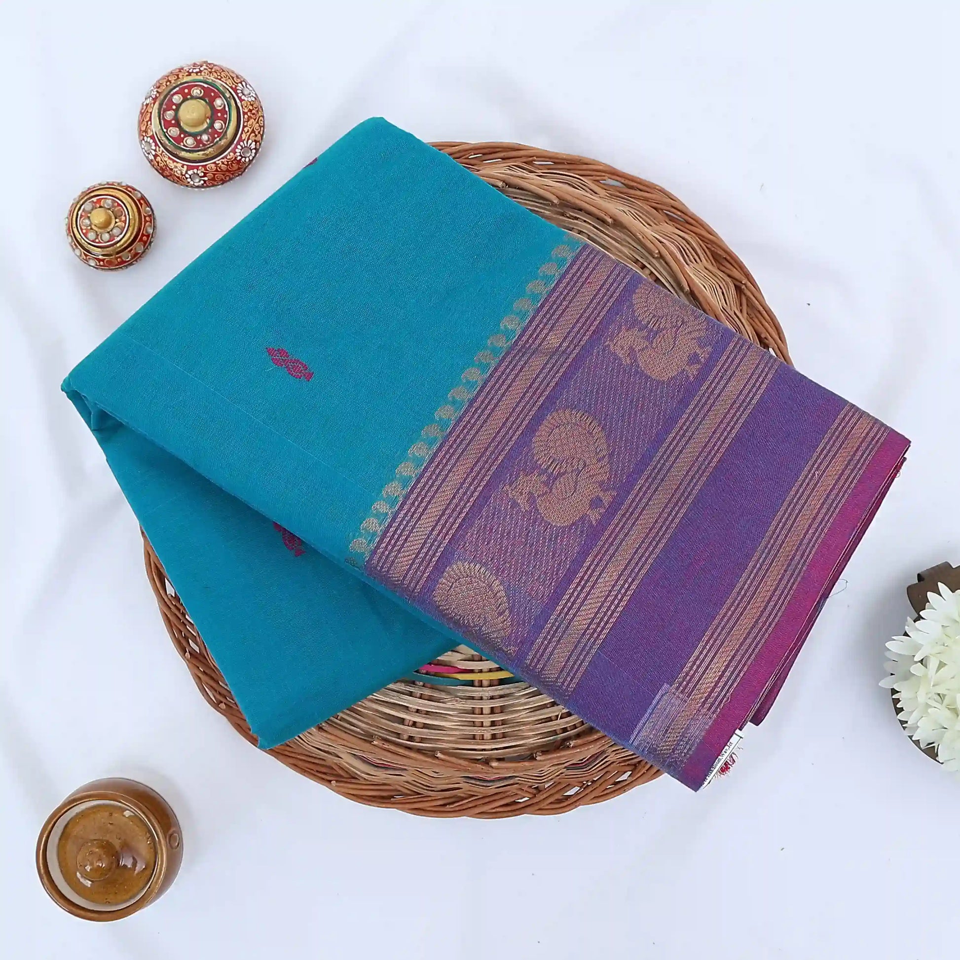Chettinad cotton saree with peacock buttas and peacock zari woven border in teal green folded top view
