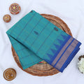 Chettinad cotton saree with teal striped body blue temple zari border and black butta motifs folded flat lay view