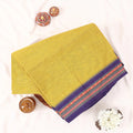 Chettinad cotton saree with plain body and temple border in yellow and purple folded top view