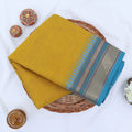 Chettinad cotton saree with plain body and temple zari woven border in yellow folded top view
