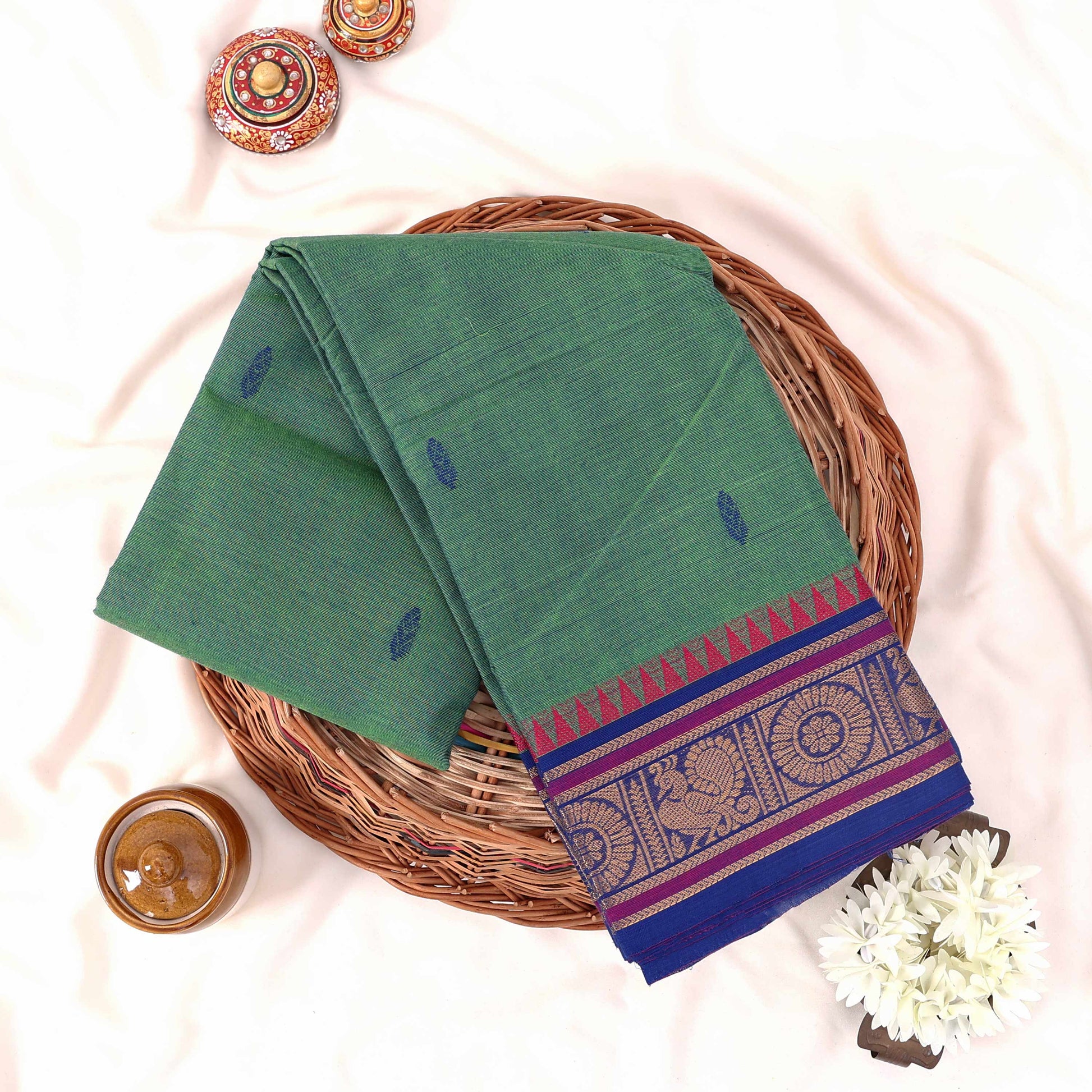 Kanchi Cotton Saree With Purple And Gold Zari Border In Sea Green Shade Folded Flat Lay View With Decorative Styling
