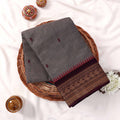 Kanchi Cotton Saree With Grey Striped Weave Maroon Motifs And Zari Border Folded Flat Top View With Decorative Styling
