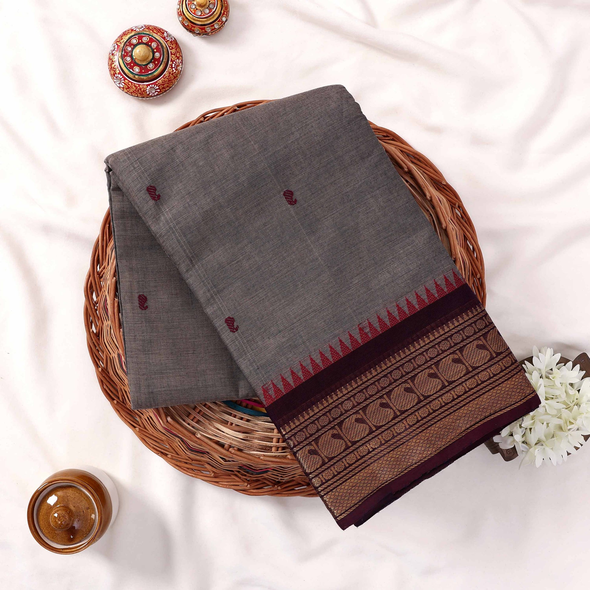 Kanchi Cotton Saree With Grey Striped Weave Maroon Motifs And Zari Border Folded Flat Top View With Decorative Styling
