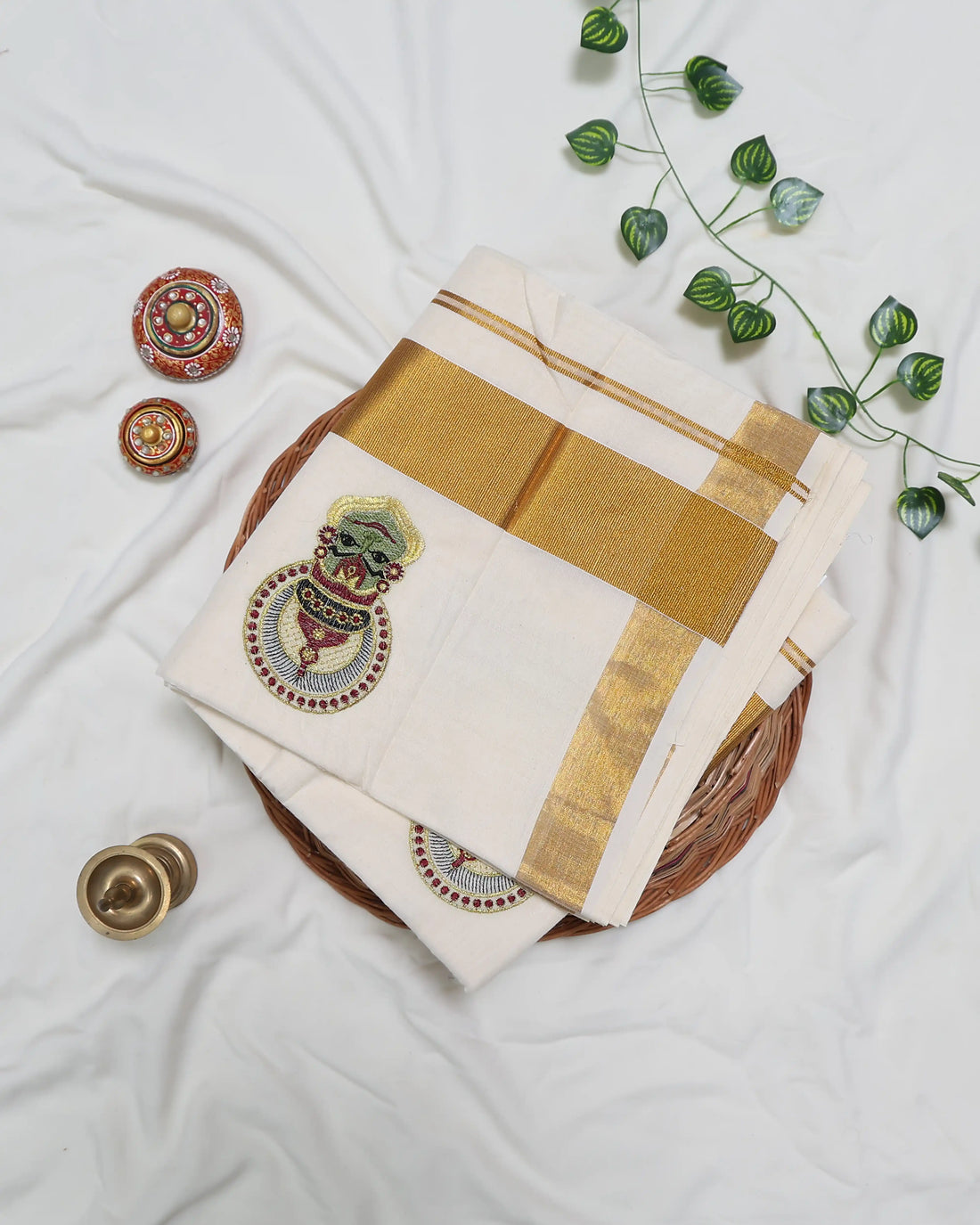 An off-white cotton saree with gold zari borders and small gold dots full view