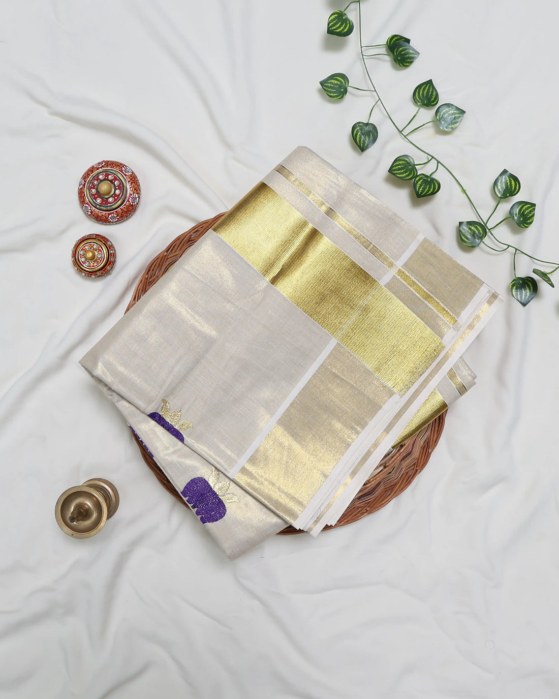 A cream-colored silk saree with small purple and gold floral motifs - full view